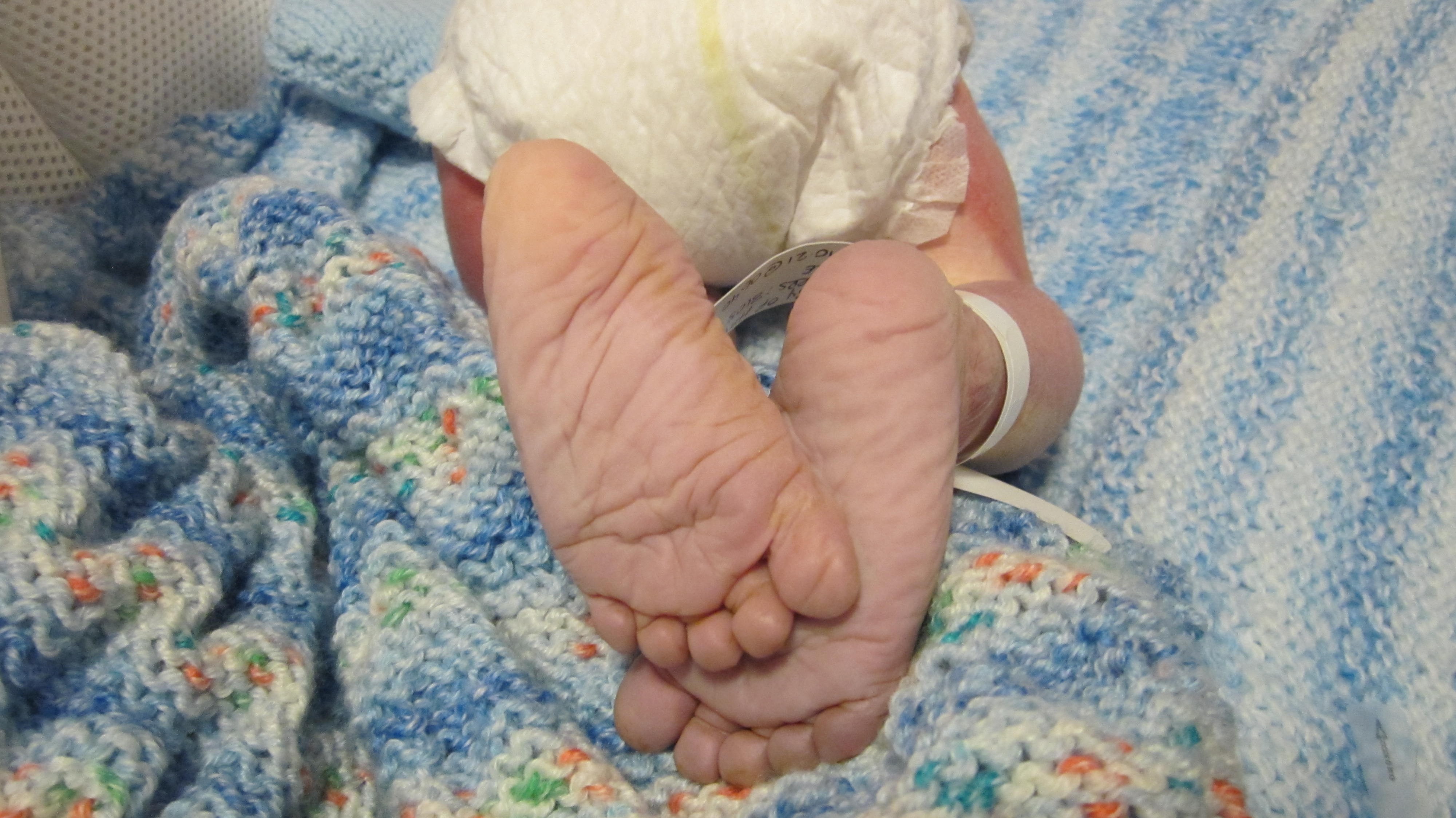 Baby feet on a blue and white knitted blanket