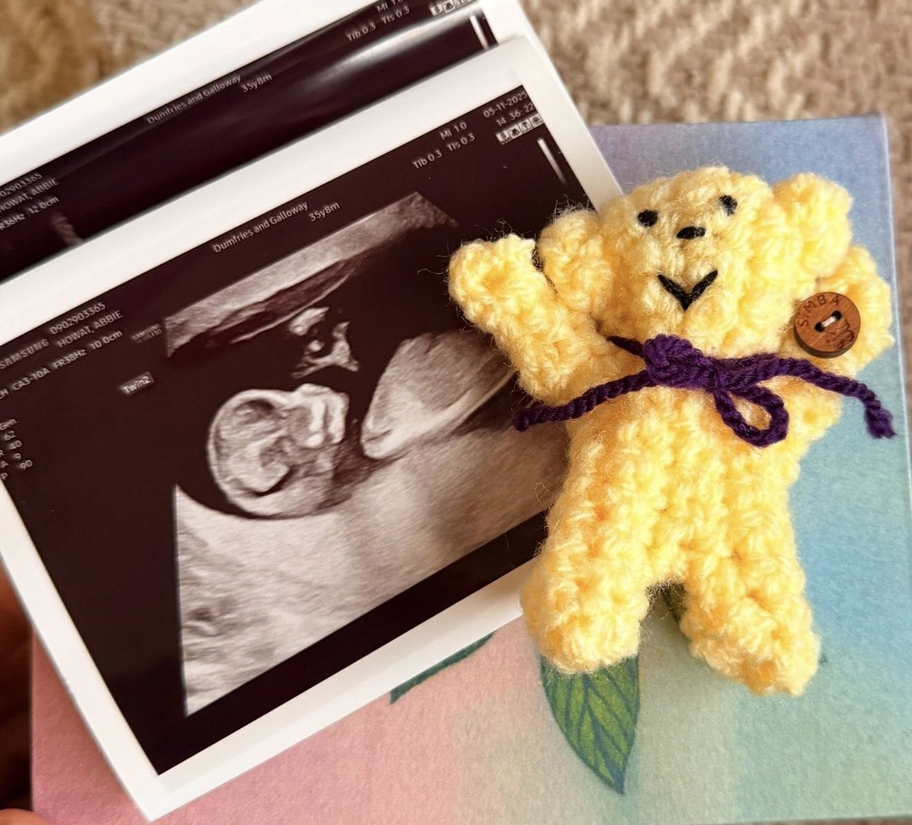 baby scan photo next to little yellow knitted teddy bear