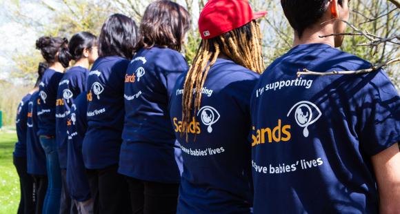 image of people lined up with sands t-shirt on
