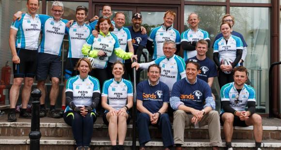 A company fundraising team gathers together in their Sands t-shirts