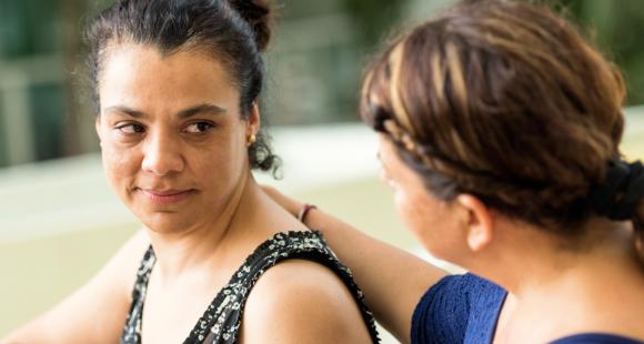 An image of one lady comforting another lady by placing her hand on her back