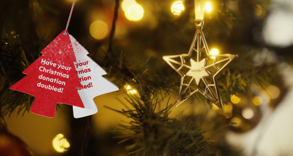 red tree decorations with words "double your donation"