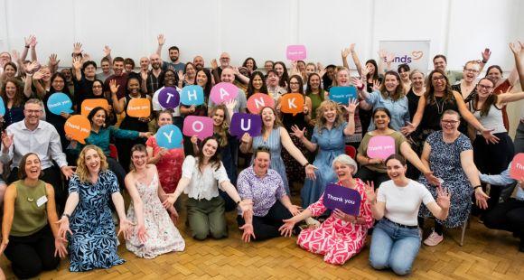 Members of Sands' staff team are gathered together holding 'thank you' signs
