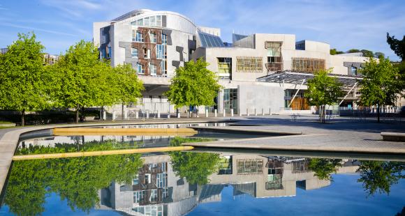 An image of the front of the Scottish Parliament with reflection in the water