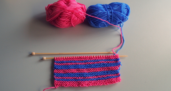 pinka nd blue yarn being knitted together
