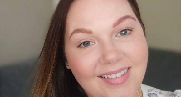 A lady with auburn hair smiling at the camera
