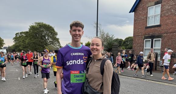 Two people in crowd posing for photo