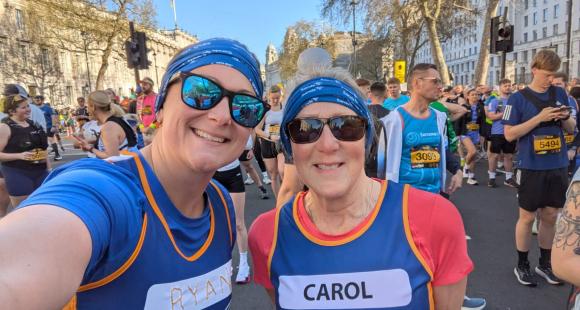 Two female Sands runners, posing for a photo wearing Sands branded running tops and bandanas.