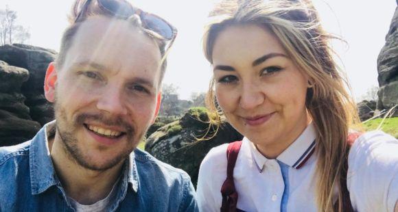 A man and woman smile at the camera