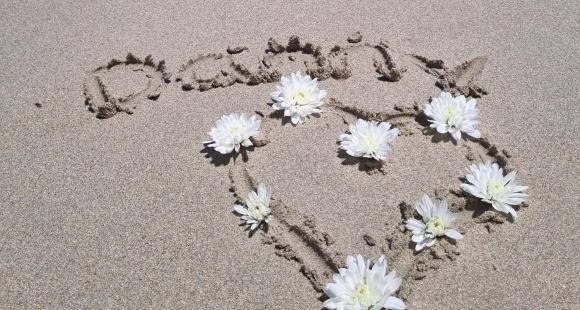Danny's name spelt out in the sand on a beach
