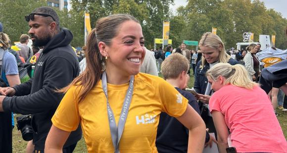 Female runner wearing royal park finisher t-shirt in yellow and wearing their race medal