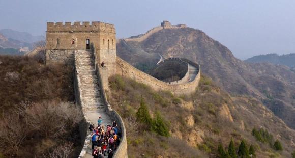 The Great Wall of China with a group of people trekking.