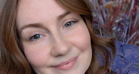 A lady with auburn hair smiling at the camera