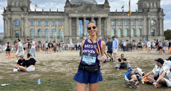 Female runners sanding holding a medal