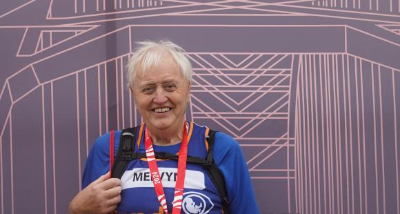 Male Sands runner standing with their race medal