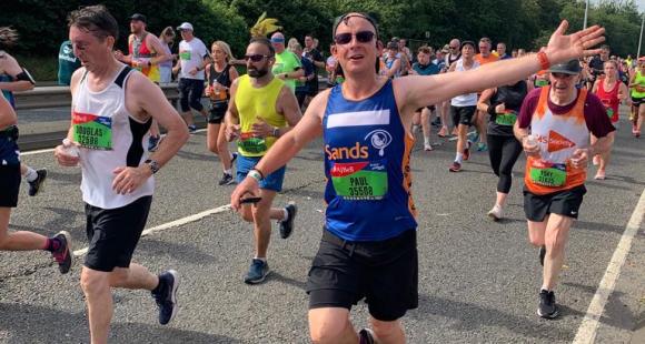 A male Sands runner, running and waving.