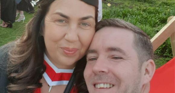 Lady with a graduation hat on smiling at the camera with her husband