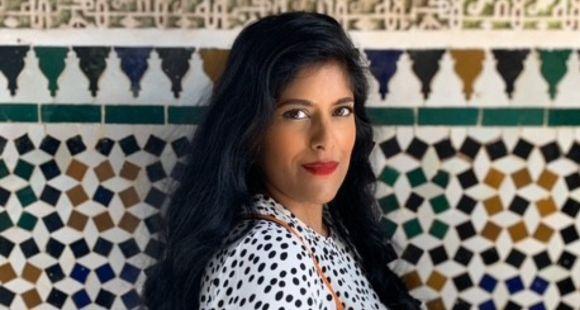 A lady with long dark hair and red lipstick looks at the camera after experiencing a second trimester loss.