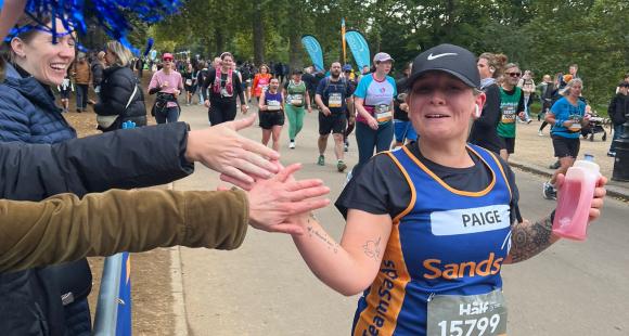 Sands running past cheer point high fiving spectators on race route