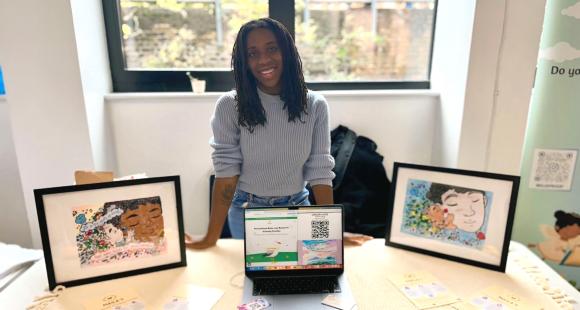 An image of Helena stood behind a desk displaying her personalised baby loss books