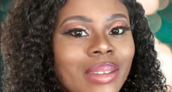 Photograph of Tolu smiling at the camera n a plain background