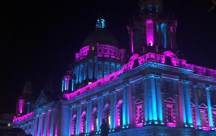 Image of a building lit up in pink and blue