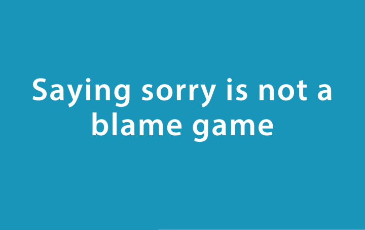 white text reading 'Saying Sorry is not a Blame Game' on a turquoise blue background