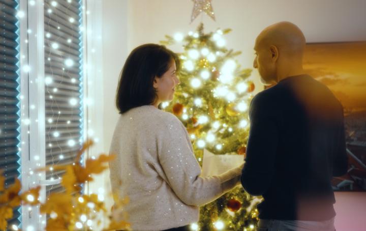 image of two people Infront of a Christmas tree 