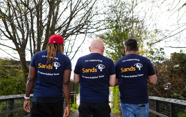 A group of parents wearing Sands t-shirts, walking into the distance.