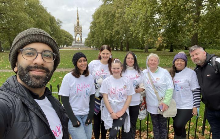 A group of people stood together in a park before taking on their Ribbon Run