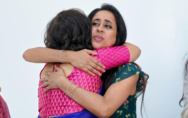 Two ladies comforting each other with a hug