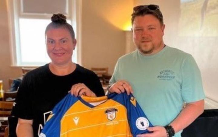 couple holding Sands United Football shirt