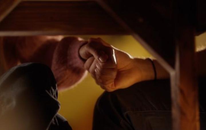 couple holding hands under a table