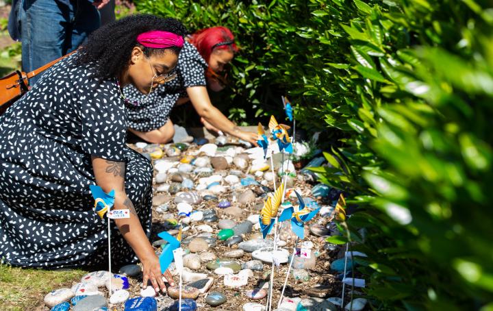 A lady places her stone down in the Sands Garden at the National Memorial Arboretum in memory of her baby