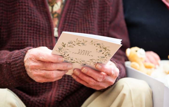 Older man holding certificate from memory box