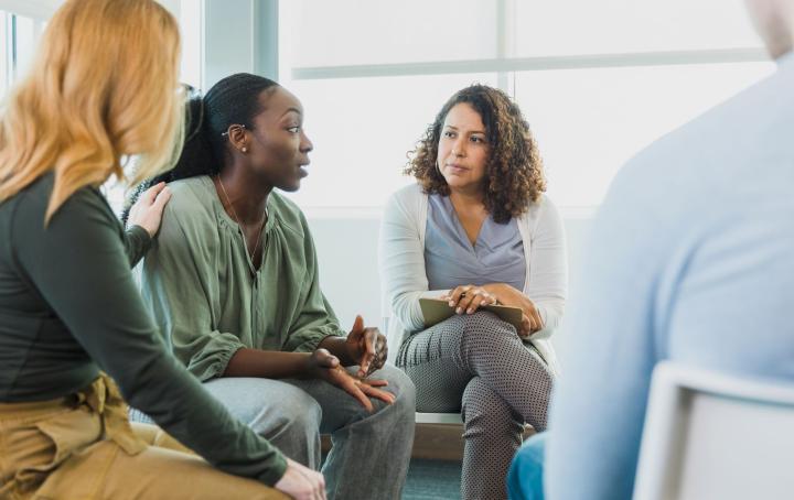 Three seated women having a discussion