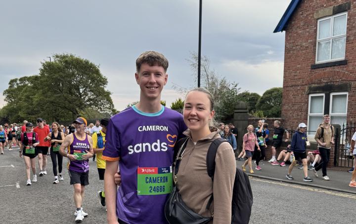 Two people in crowd posing for photo