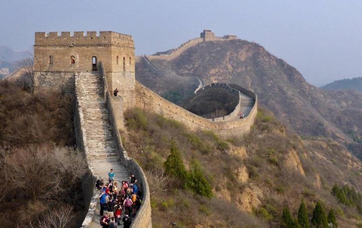 The Great Wall of China with a group of people trekking.