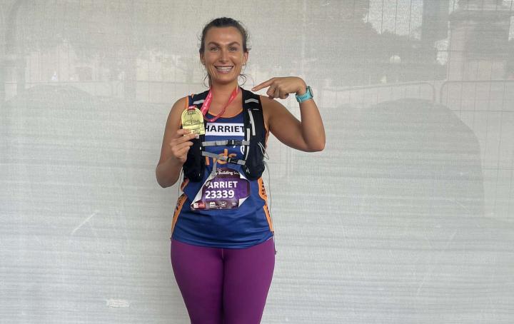 Sands runner holding a medal and point to the medal