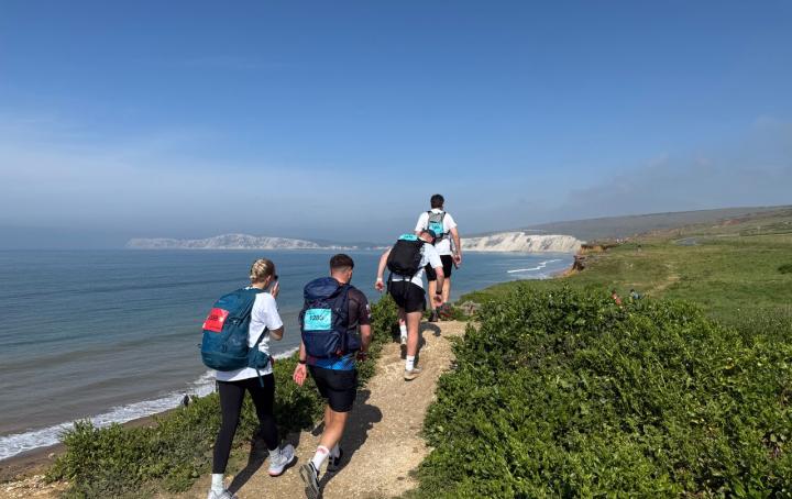 Group of people walking, blue sea and white cliffs.