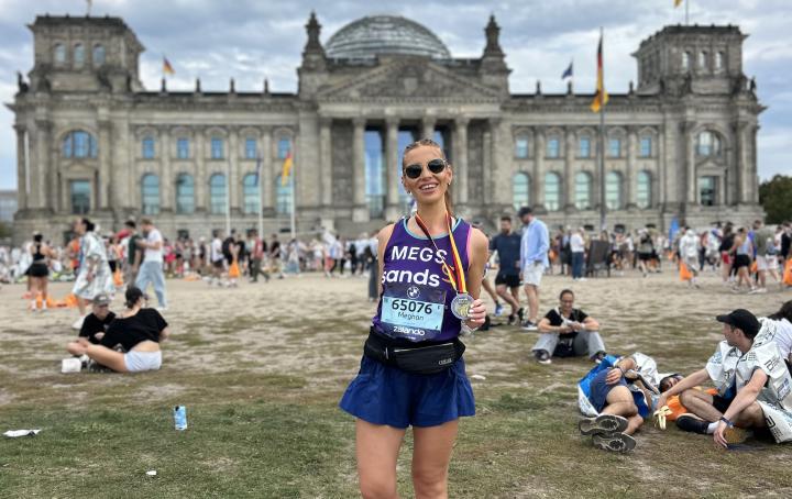 Female runners sanding holding a medal