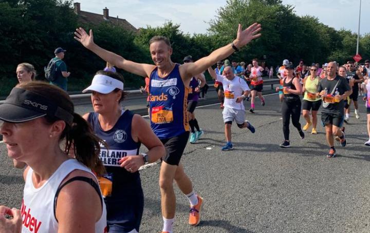 A Sands running with hands up in the air of celebration.