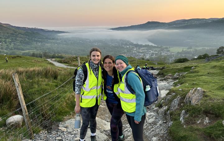 3 women in front of the view from below of Snowdon