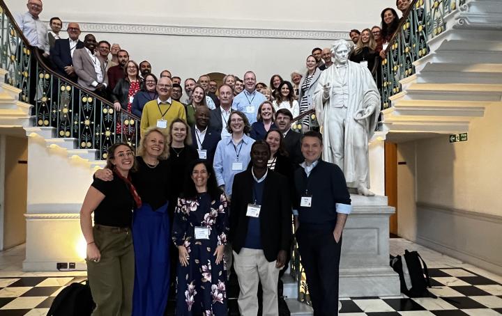 A large group of people span a double staircase whilst posing for a photograph 