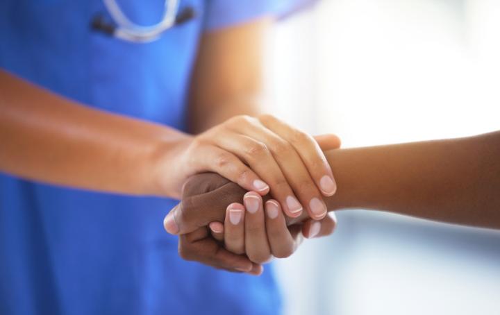 Health professional holds someone's hand
